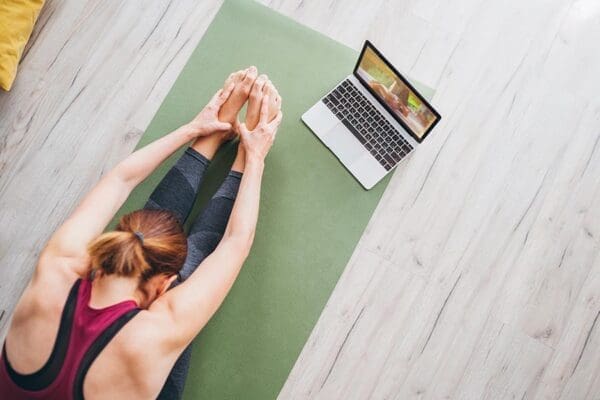 Woman doing yoga with her laptop