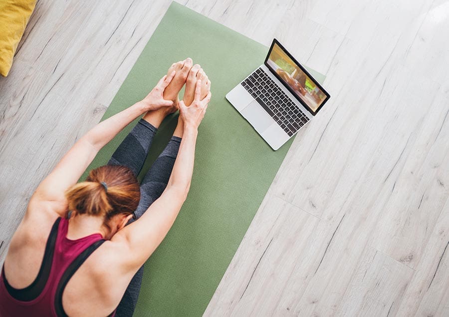 Woman doing yoga with her laptop