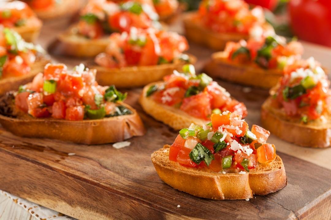 Fresh homemade bruschetta with tomatoes, basil, and garlic on toasted bread, topped with parmesan cheese.